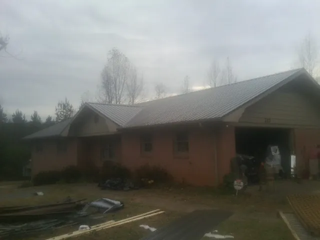 Gray metal roof on a stucco house with an attached garage in Greenback