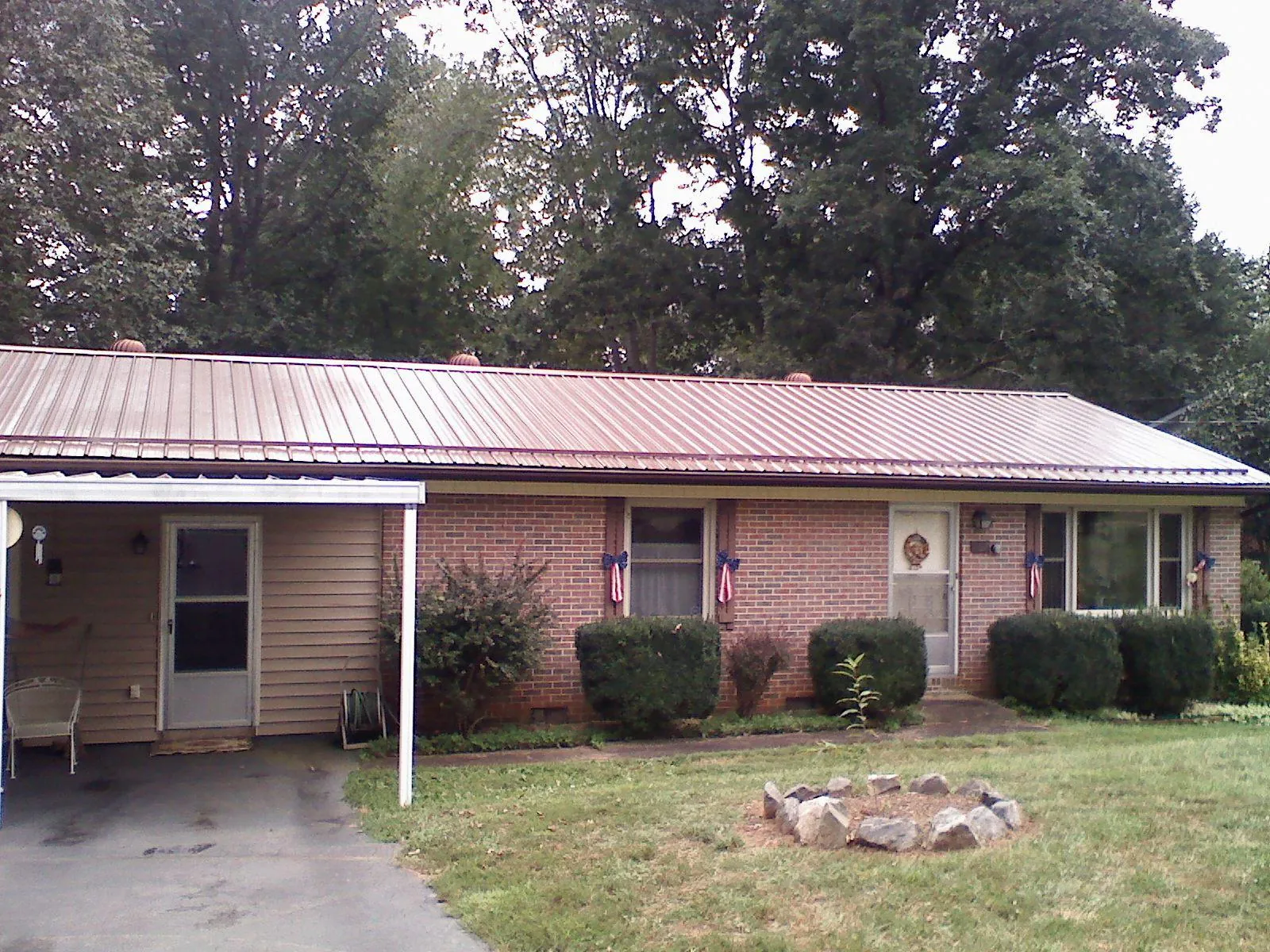 Bronze metal roof and carport on a brick ranch home — Roof Repair work by our crew in Greenback